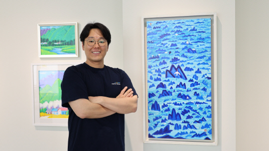 핀휠 유명곤 대표, 허남성 작가의 '춤추는 산과물' 앞에서 사진 촬영